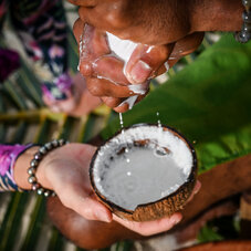 Photo d'une personne qui essore un tissu pour en faire couler le lait de coco